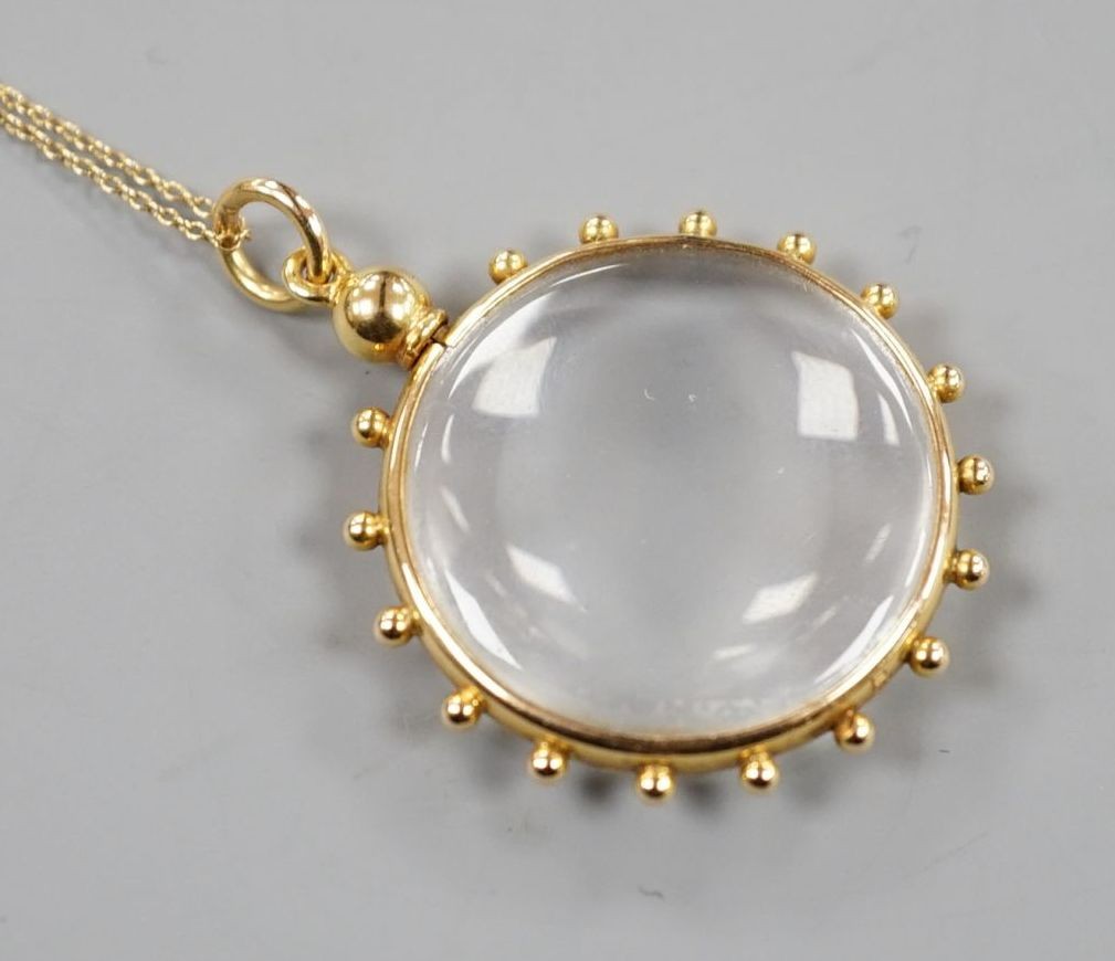 An early 20th century 15ct mounted eye glass pendant, 29mm, on a yellow metal fine link chain, gross 9.3 grams.